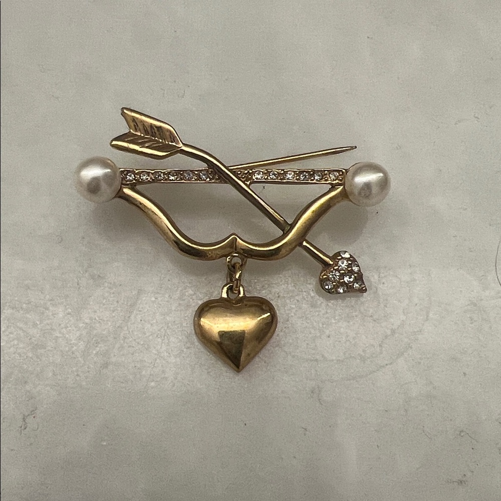 Decorative brooch . Gold color Metal, rhinestones.